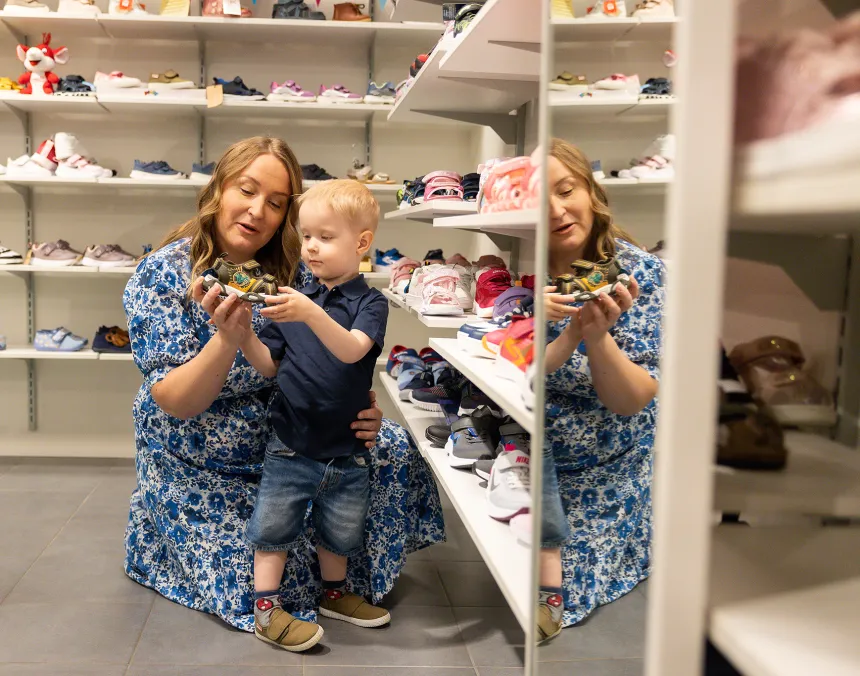 Mamma och barn tittar på skor